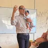 الدكتور وليد عفيفي، عميد كلية التجارة جامعة كفر الشيخ وهو يحمل الصغيرة أثناء شرح المحاضرة 