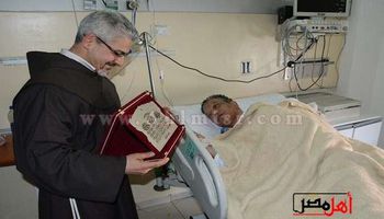 الأب بطرس دانيال يكرم محمد شرف في المستشفى