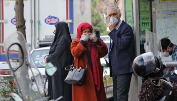 إيرانيون في أحد شوارع طهران يرتدون كمامات للوقاية من انتشار فيروس كورونا
