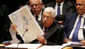 الرئيس الفلسطيني ممسكا بخريطة دولة فلسطين المستقبلية وفقا لخطة ترامب (REUTERS )