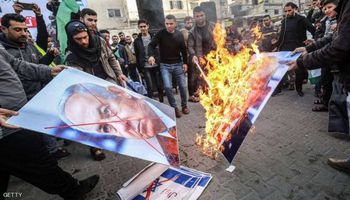فلسطينيون يحرقون صور نتانياهو وترامب رفضا للخطة الأمريكية (GETTY)