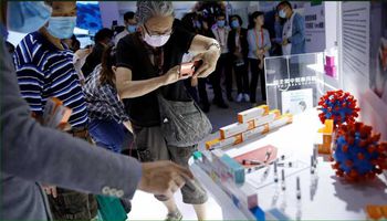 صينيون يلتقطون صورا للقاحات المحتملة لكورونا بمعرض في بكين