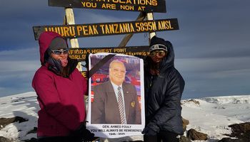 منسقة المؤسسة الإنسانية للتايكوندو ترفع صورة الراحل "أحمد فولي" على قمة جبل كليمنجارو