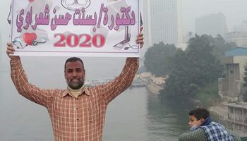 أب يحمل لافتة على كوبري عباس احتفالًا بتخرج ابنته