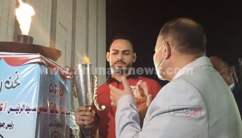 حسام ميرغنى بطل المصارعة يحمل شعلة أولمبياد الطفل المصرى فى أسيوط