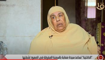 الداخلية تساعد سيدة مصابة بالسمنة المفرطة فى الصعود لشقتها