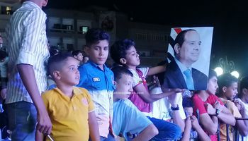 اطفال يحملون صور الرئيس السيسي في احتفالات اكتوبر