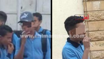 طلاب التعليم المفتوح يدخنون السجائر أثناء خروجهم من المدرسة