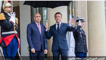 ماكرون يمسك المظلة للرئيس الموريتاني