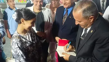 محافظ بورسعيد يهدى طفلة كتاب بتوقيعه