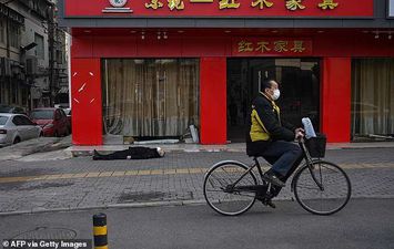 رجل طريح الأرض ميتا بإحدى شوارع ووهان الصينية، مركز تفشي كورونا (AFP via GETTY images)