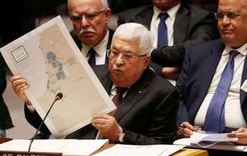 الرئيس الفلسطيني ممسكا بخريطة دولة فلسطين المستقبلية وفقا لخطة ترامب (REUTERS )