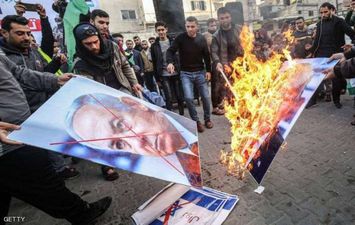 فلسطينيون يحرقون صور نتانياهو وترامب رفضا للخطة الأمريكية (GETTY)