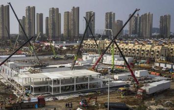 مئات عمال البناء أثناء عملهم على بناء مستشفى جديد في ووهان (GETTY)