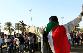 متظاهر سوداني يحتفل بالذكرى الأولى لثورة السودان (REUTERS )