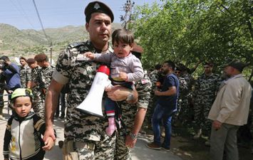 أحد عناصر الأمن اللبناني يحمل أطفال سوريين حاولوا تسلل الحدود رفقة ذويهم