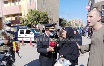 رجال الشرطة يوزوعون الورود على المواطنين في قنا