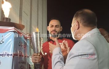 حسام ميرغنى بطل المصارعة يحمل شعلة أولمبياد الطفل المصرى فى أسيوط