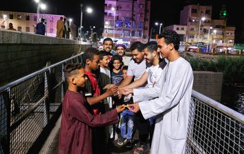 بالصور.. الأقباط يوزعون حلوى المولد النبوى على المسلمين بشوارع مدينة إسنا في الأقصر 