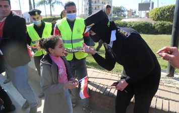 رجال الشرطة يوزعون الحلوى والورود والأعلام على المواطنين والمارة بكفر الشيخ