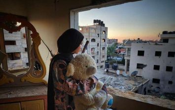 طفلة فلسطينية تحتضن ألعابها بعد قصف منزلها