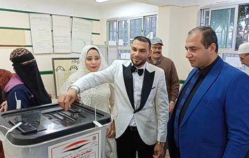 العروسين أثناء الإدلاء بصوتهما في الانتخابات 