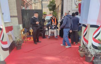 على كرسي متحرك.. قوات الأمن تساعد مسن للمشاركة في الانتخابات الرئاسية بالجيزة