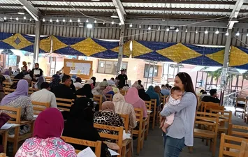دكتورة جامعية تحمل طفل رضيع والدته تؤدى امتحانها و تتعثر بسبب بكائه فى الكتابة 