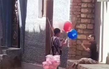 طفل يهدي شاب من ذوي الاحتياجات حلوي