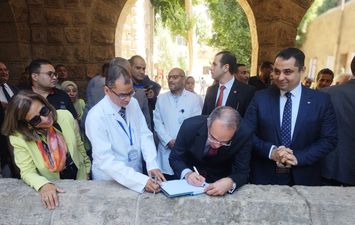 وزير الاتصالات اثناء كتابته تهنئة الحميات بقنا