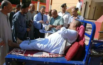 مواطن من إسنا يدلي بصوته في انتخابات مجلس النواب محمولًا على تروسيكل