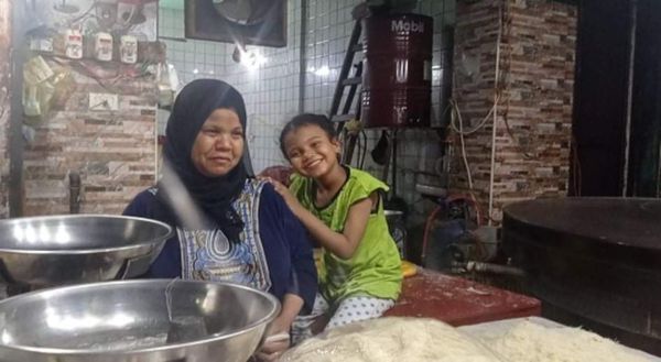 فاطمة بائعة الكنافة في نجع حمادي مع طفلتها الوحيدة