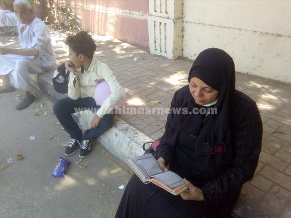 سيدة تقرأ القرآن الكريم لتوفيق ابنتها في امتحان اللغة العربية للثانوية العامة بالأقصر 