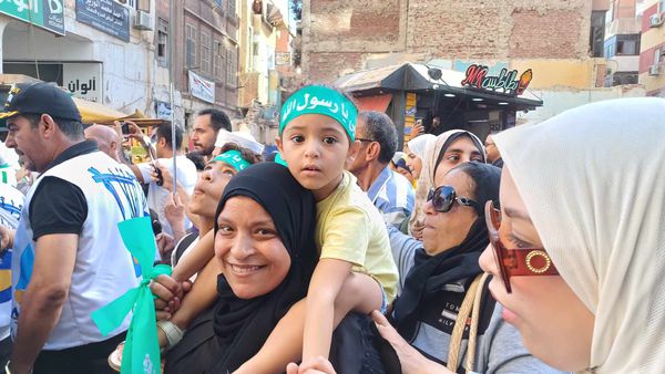 سيدة تحمل طفلها اثناء الاحتفال بالمولد النبوي ببورسعيد 