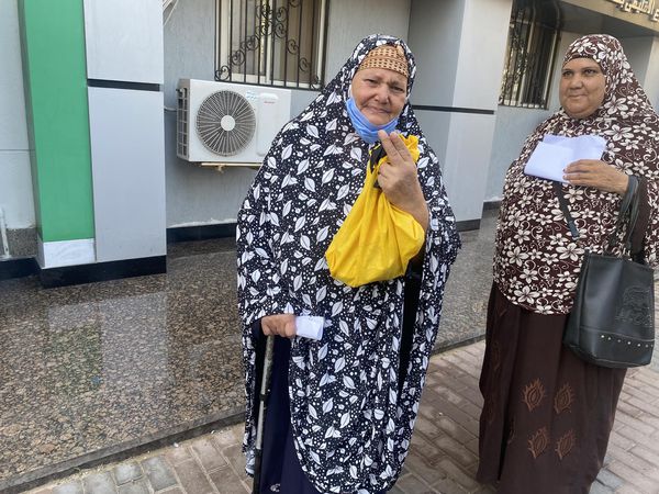 سيدة مسنه ترفع علامة النصر امام مكتب بالشهر العقارى ببورسعيد