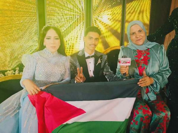 أنا دمــي فلســطيني.. عروسان يحتفلان بزفافهما رافعين علم فلســطين في بورسعيد