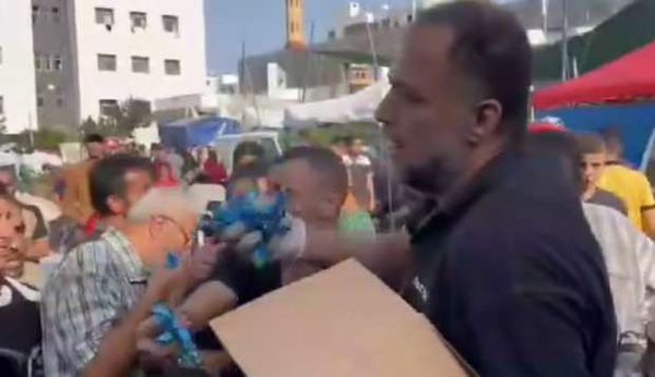 رجل فلسطيني يوزع حلوى بعد استشهاد جميع أفراد عائلته