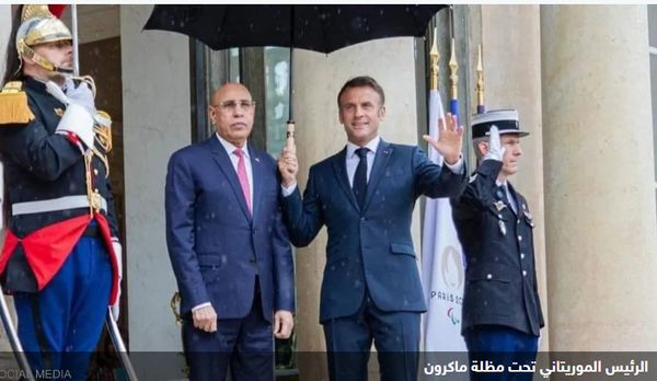 ماكرون يمسك المظلة للرئيس الموريتاني