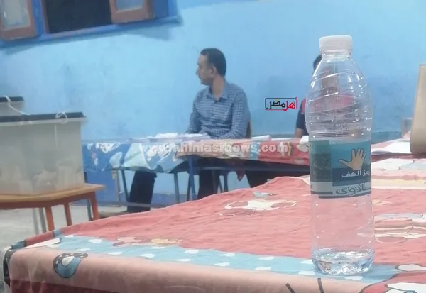 رمز المرشح على زجاجة المياه المعدنية داخل اللجان بقنا 